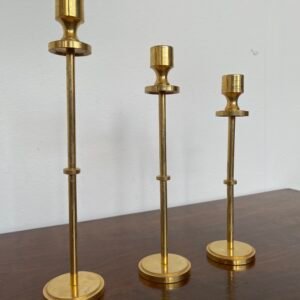 Tris di portacandele modernisti in ottone lucido, dal design minimalista ed elegante.